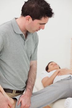 Physiotherapist stretching the leg of a woman in a room