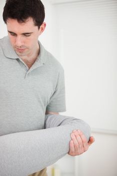 Brunette physiotherapist stretching a leg in a room