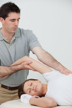 relaxed woman being stretched by a physiotherapist in a room