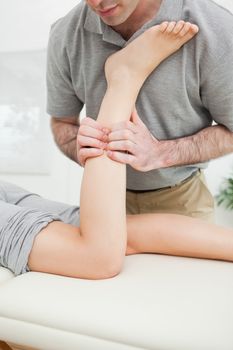 Close-up of a man massaging the leg of a woman in a room