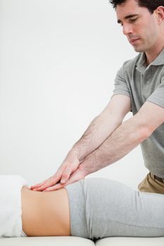 Close-up of a masseur massaging the back of a woman in a room