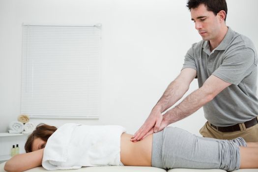 Man standing while massaging the back of a woman in a room