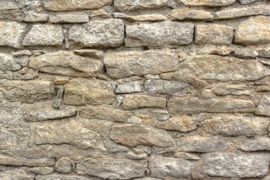 old stone wall texture at the exterior of an abandoned house