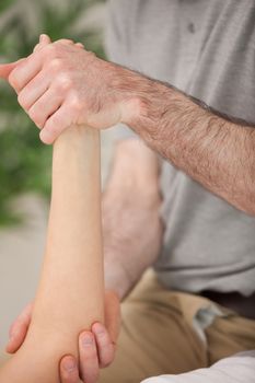 Ankle and elbow of a patient being manipulated in a medical room