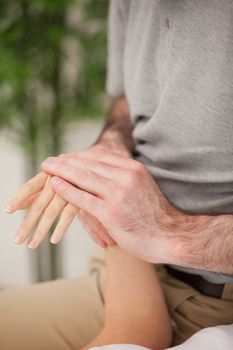 Doctor rubbing the hand of a patient in his medical room