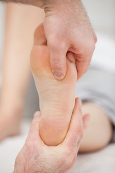 Doctor pressing his thumb on a foot in a room