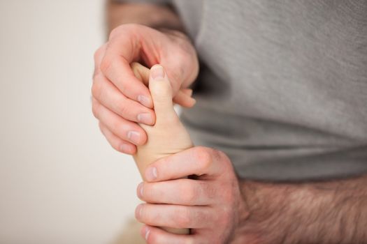 Doctor manipulating the fingers of a patient in his office