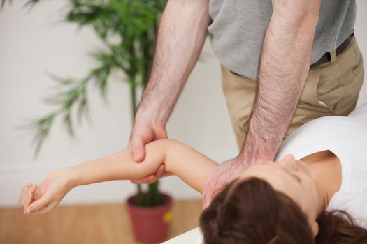 Woman lying on a medical table while being manipulated in a room