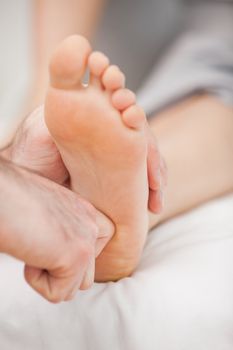 The ball of a foot being massaged in a room