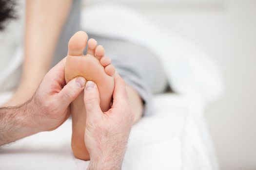 Foot being massaged on a medical table in a room