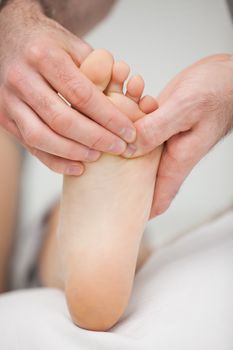 Foot being touched by a chiropodist in a room