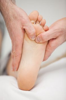 Chiropodist massaging the foot of a patient in a medical room