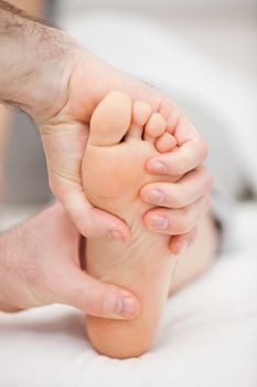 Foot being held by two hands in a medical room