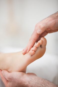 Physiotherapist offering a foot massage in a medical room