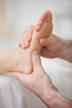 Foot receiving a massage by a physiotherapist in a medical room