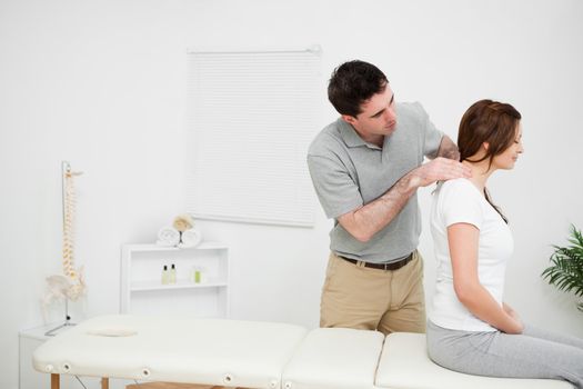 Physiotherapist massaging a brunette woman in a medical room