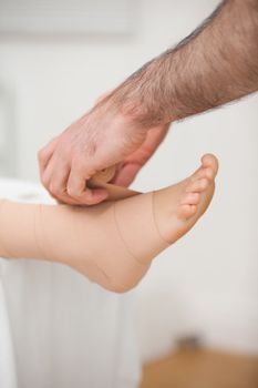 Doctor bandaging an ankle in a medical room