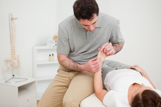 Physiotherapist looking at the wrist of a patient in a room