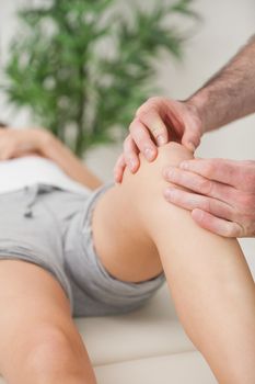 Fingers of a doctor massaging a leg in a room