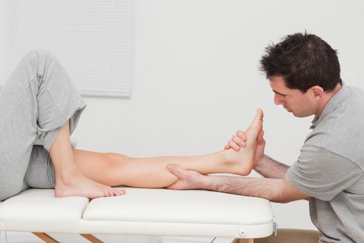 Calf of a patient being massaged by a physiotherapist in a room