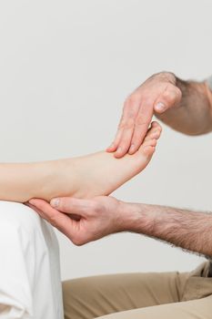 Practitioner holding the foot of a patient in a room