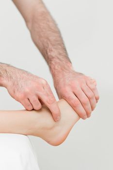 Physiotherapist touching the foot of a patient in a room