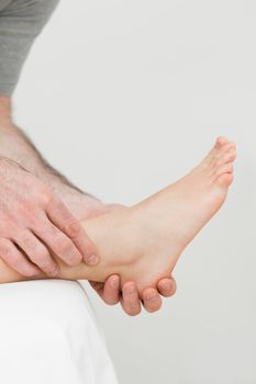 Ball of a foot being held by a practitioner in a room