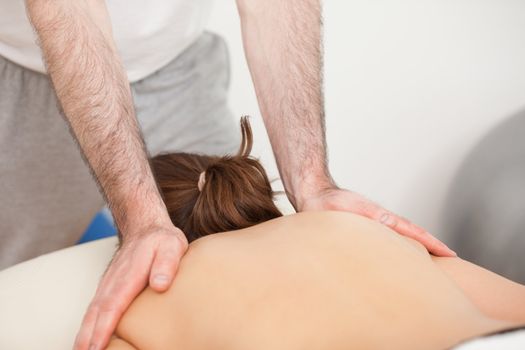 Shoulders of woman being massaged by doctor in a room