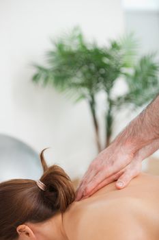 Practitioner massaging the top of back of his patient indoors