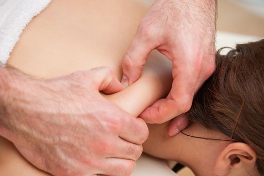 Back of woman being squeezed by hands of doctor in a room