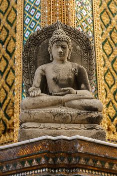 Buddha stone sit in meditation position statue against beautiful gold pattern background