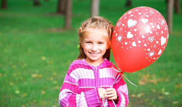 little girl with red balloon  in the park