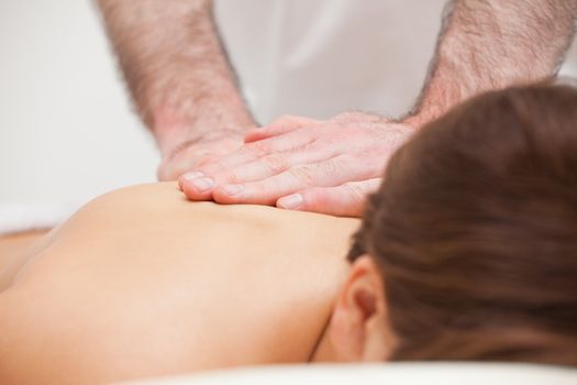 Close-up of a doctor massaging the back of a woman indoors