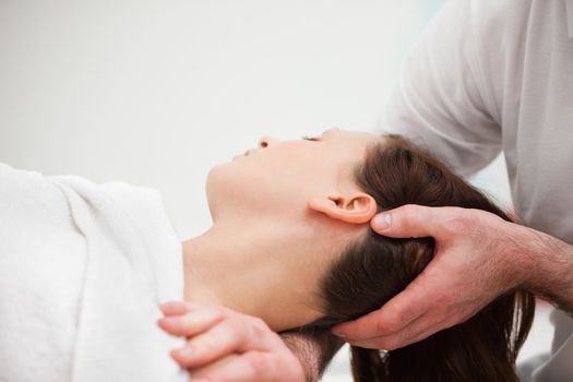 Doctor manipulating the neck of a woman in a room