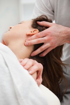 Close-up of chiropractor manipulating the neck of his patient in a room