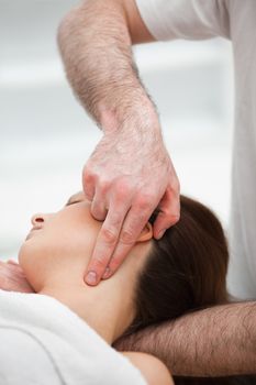 Therapist pressing with two fingers on the neck of his patient in a room