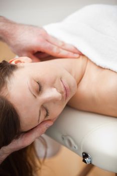 Neck of a patient being massaged by a chiropractor in a room