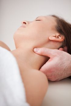 Close-up of doctor pressing his thumb on the neck of his patient indoors