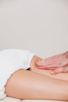 Osteopath massaging a woman on her thigh in a room