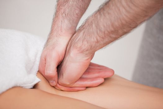 Practitioner massaging the thigh of his patient  in a room