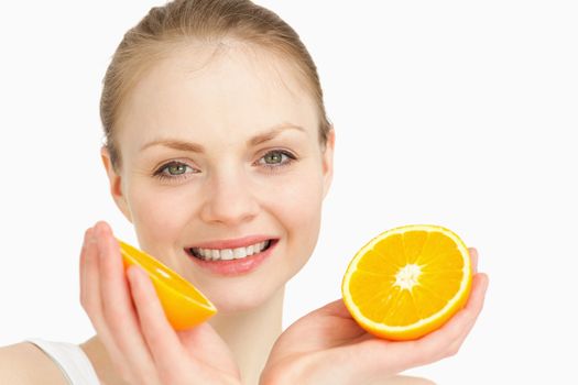 Close up of a joyful holding oranges against white background