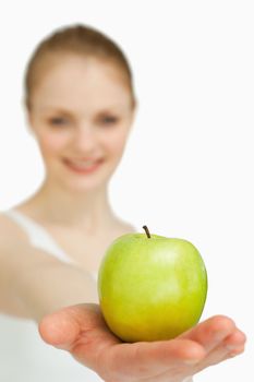 Close up of a woman presenting an apple against white background
