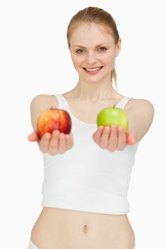 Joyful woman presenting two apples against white background