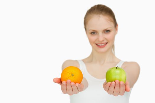 Young smiling woman presenting fruits against white background