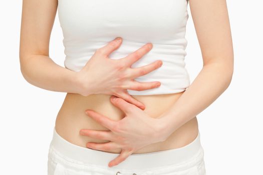 Woman touching her belly with her hands against white background