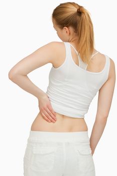 Young woman massaging her back against white background