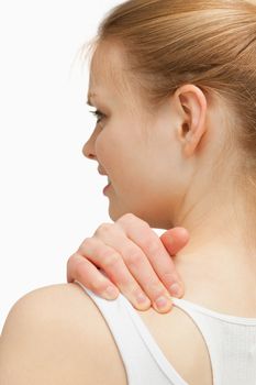 Young woman massaging her nape against white background 