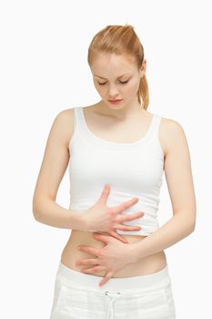 Woman placing her hands on her stomach against white background