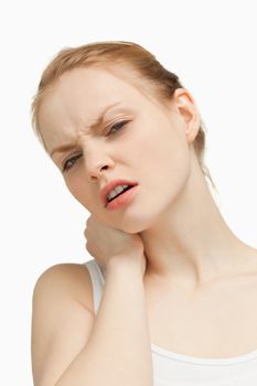 Young woman massaging her painful back against white background