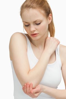 Woman touching her elbow against white background